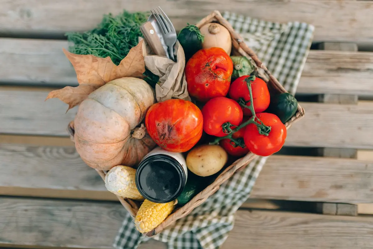 Kist met verse groenten: tomaten, pompoen, paprika en kruiden