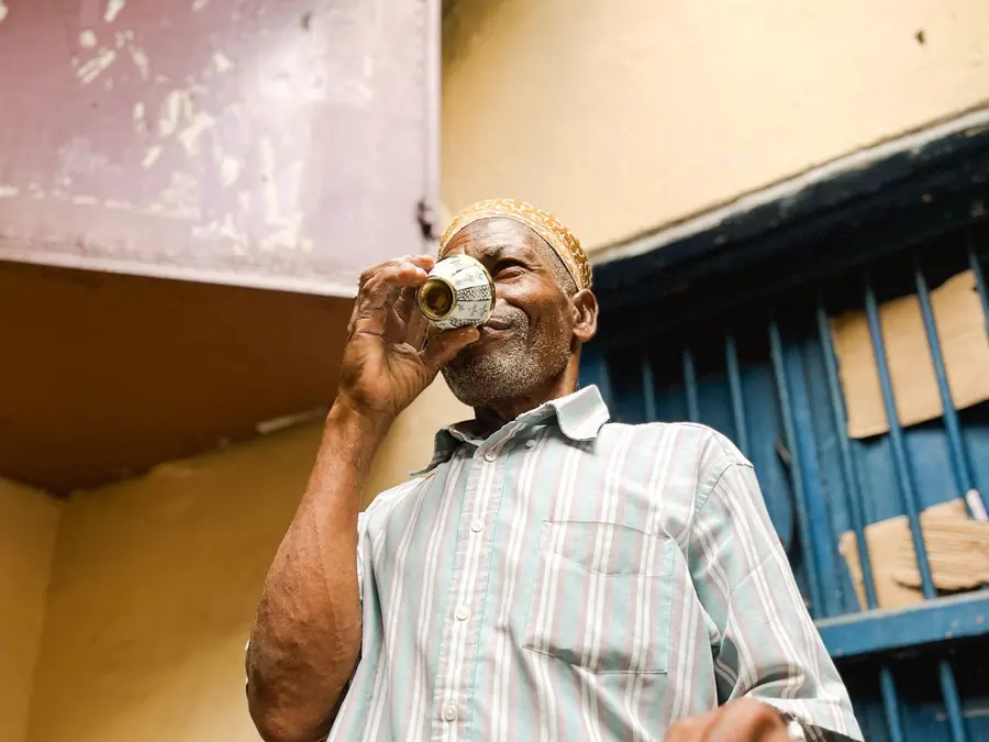 Oudere man drinkt thee uit een klein glas